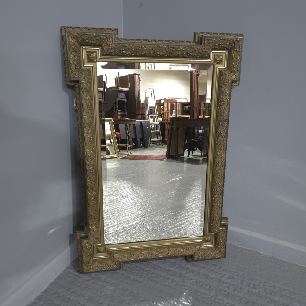 A large rectangular French giltwood wall mirror featuring elaborate carved corner mouldings and bevelled glass. View VII