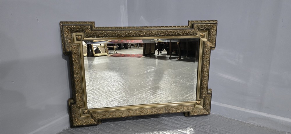 A large rectangular French giltwood wall mirror featuring elaborate carved corner mouldings and bevelled glass. View VIII