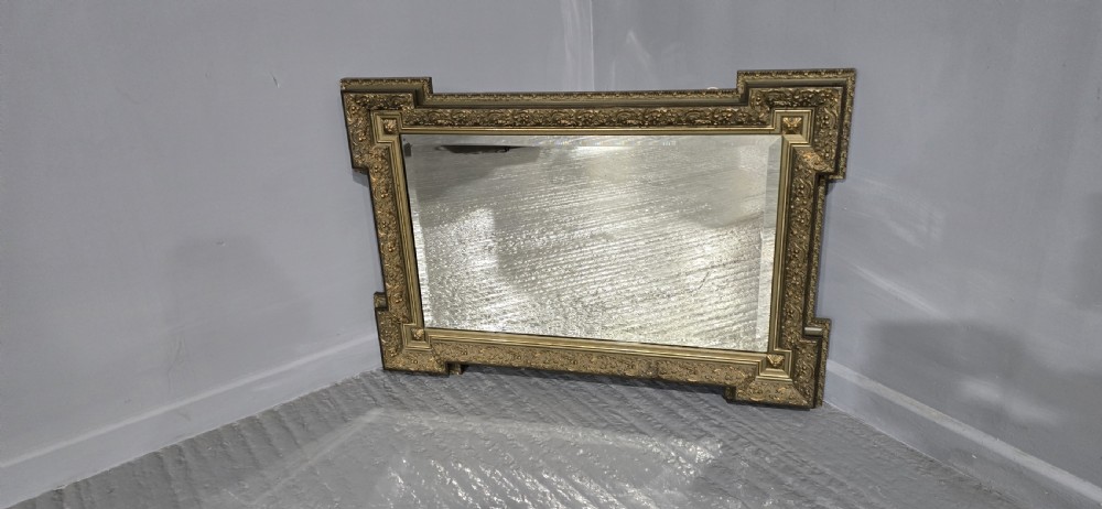 A large rectangular French giltwood wall mirror featuring elaborate carved corner mouldings and bevelled glass. View IX
