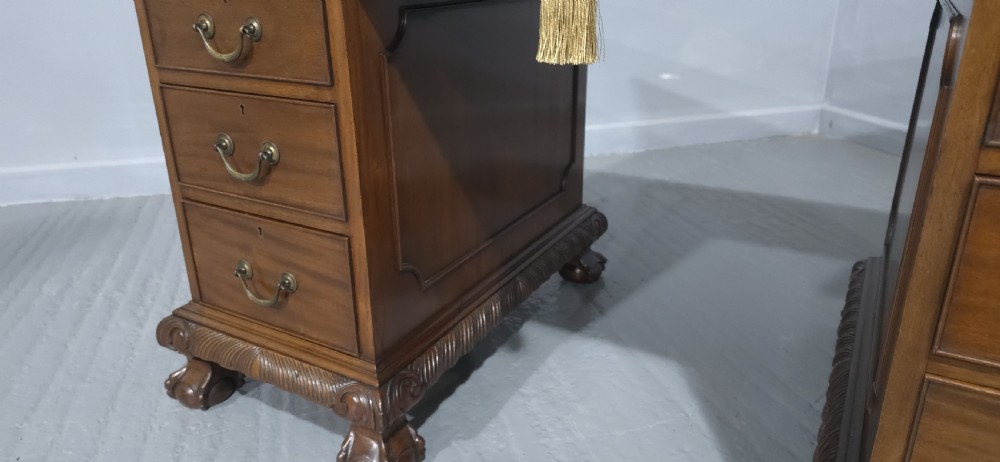 An antique mahogany pedestal desk featuring a dark leather inset surface, brass swan-neck handles, eight side drawers, a central frieze drawer, and carved claw feet. View VIII