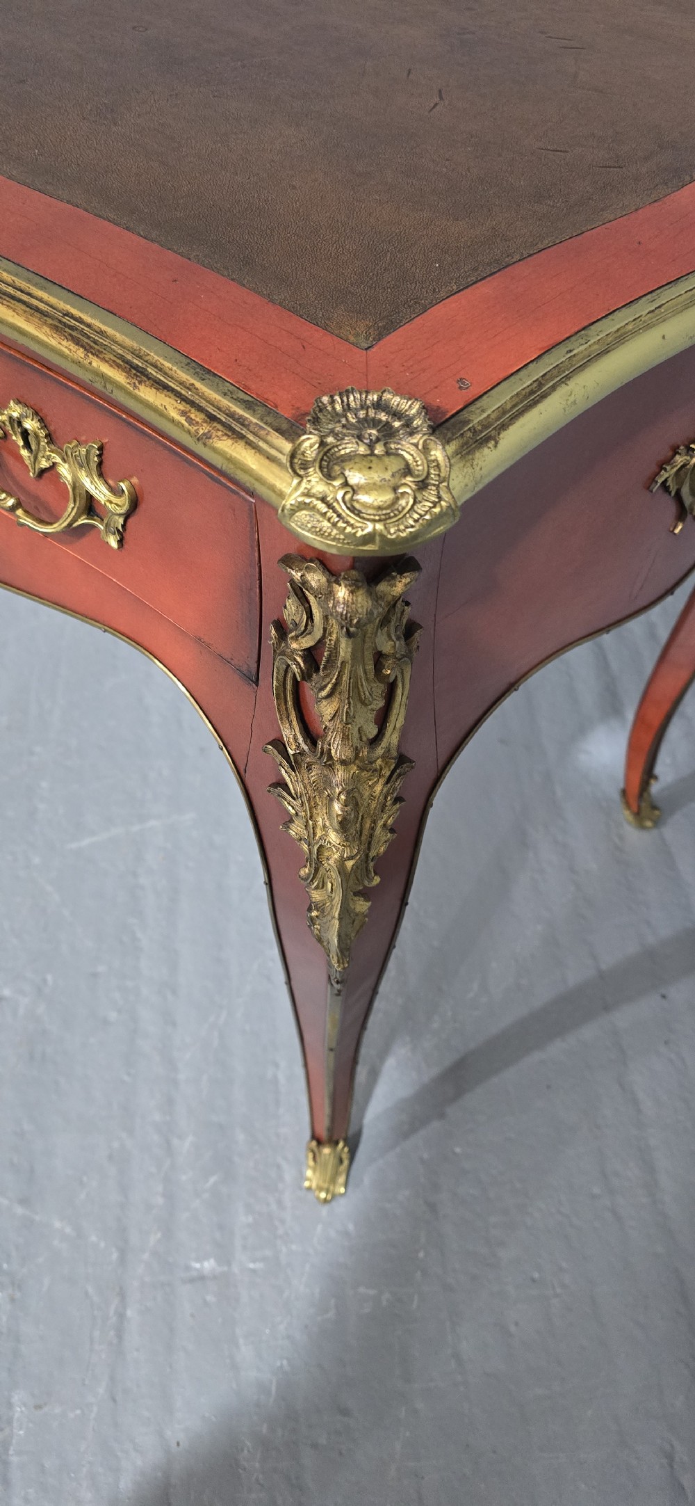 A pair of red lacquered French bureau plat writing desks featuring inset leather tops, three frieze drawers, and gilt bronze mounts on cabriole legs. View XI