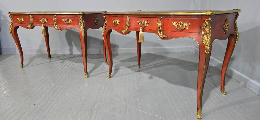 A pair of red lacquered French bureau plat writing desks featuring inset leather tops, three frieze drawers, and gilt bronze mounts on cabriole legs. View XIV