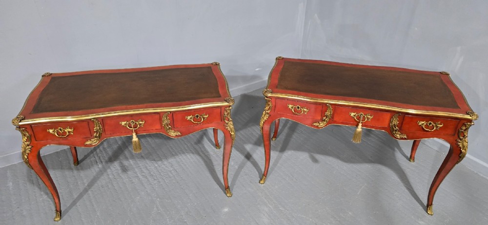 A pair of red lacquered French bureau plat writing desks featuring inset leather tops, three frieze drawers, and gilt bronze mounts on cabriole legs. View XV