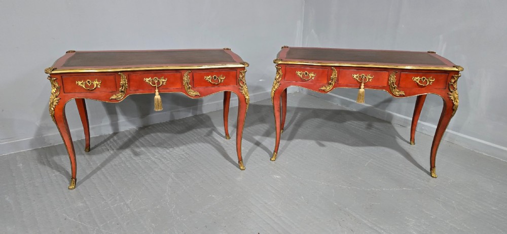 A pair of red lacquered French bureau plat writing desks featuring inset leather tops, three frieze drawers, and gilt bronze mounts on cabriole legs. View XVIII