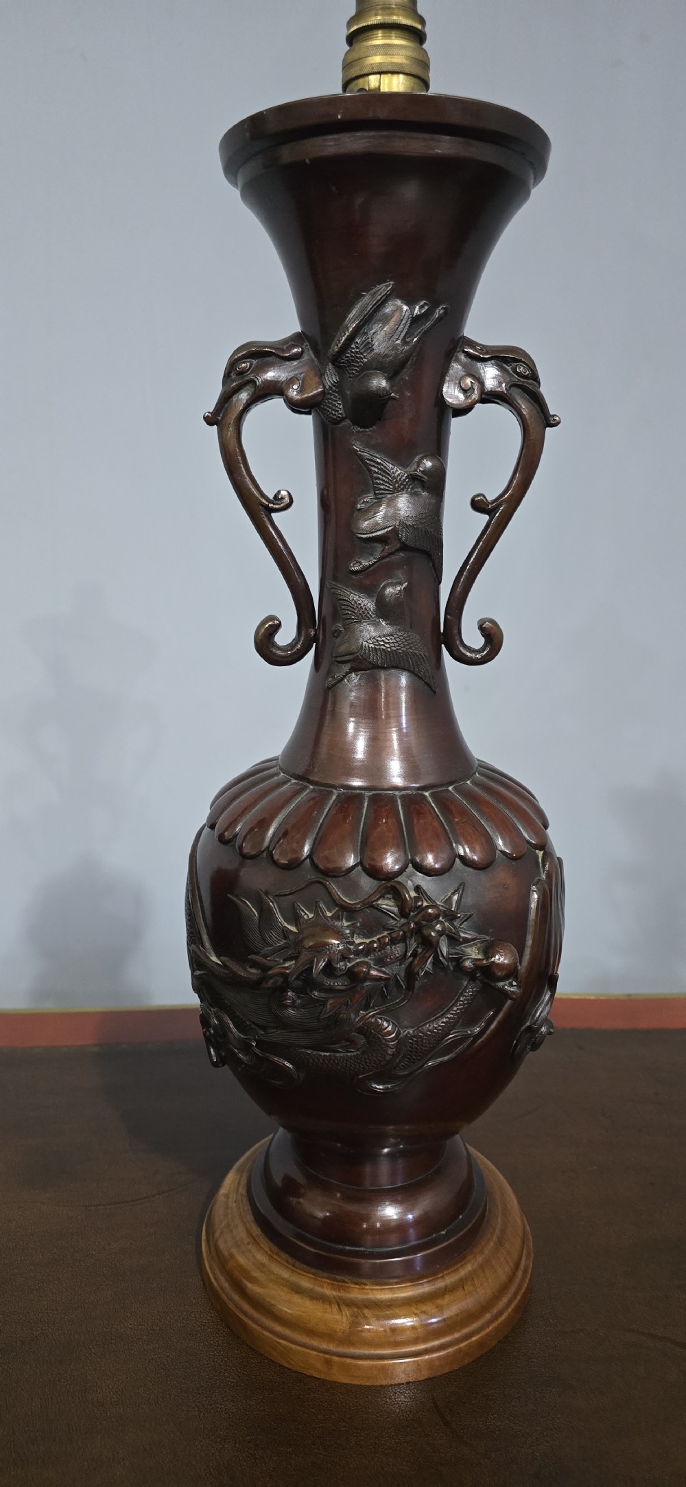 A pair of dark brown bronze urn-shaped table lamps featuring relief carvings of dragons and birds on turned wooden bases. View II