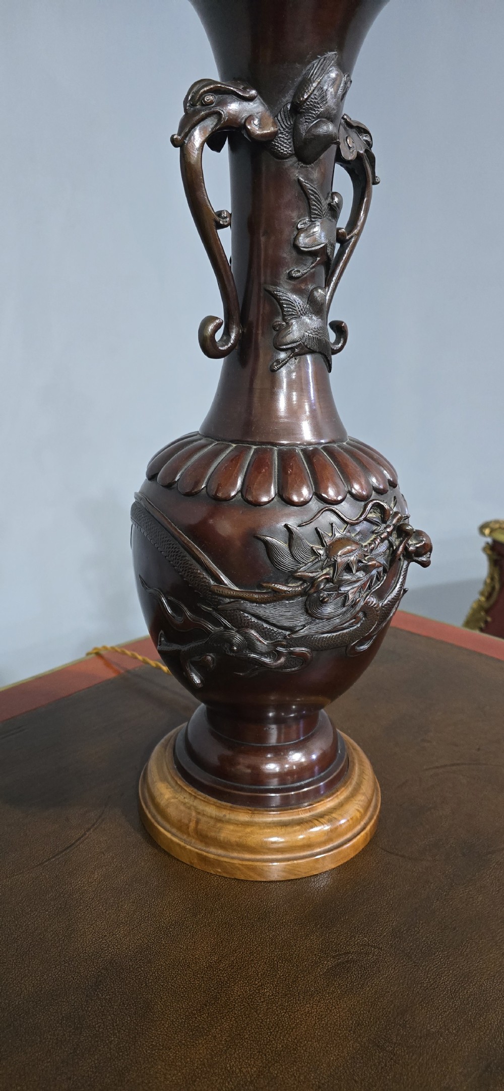 A pair of dark brown bronze urn-shaped table lamps featuring relief carvings of dragons and birds on turned wooden bases. View VII