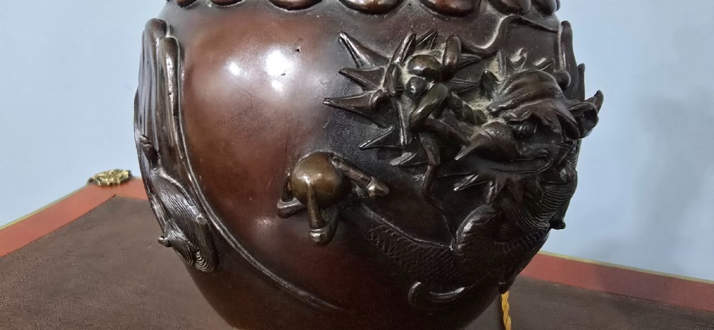 A pair of dark brown bronze urn-shaped table lamps featuring relief carvings of dragons and birds on turned wooden bases. View VIII