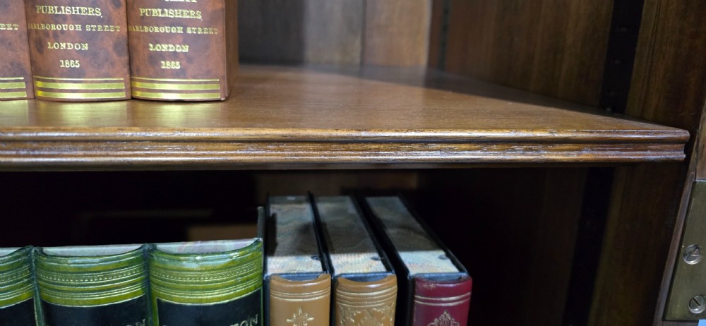 A double-door glazed burr walnut bookcase on stand featuring an arched pediment, astragal glazing bars, three lower drawers, and cabriole legs. View XXI