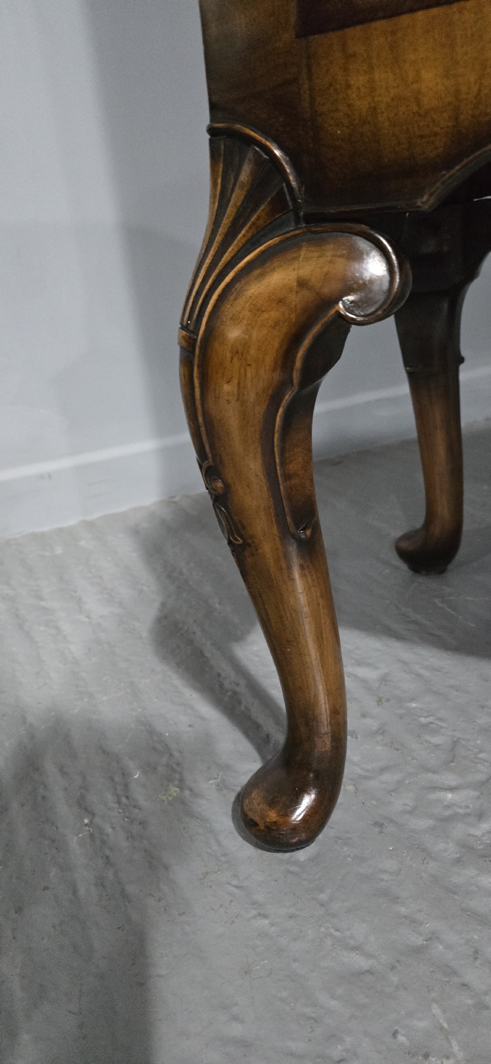 A double-door glazed burr walnut bookcase on stand featuring an arched pediment, astragal glazing bars, three lower drawers, and cabriole legs. View XXIII