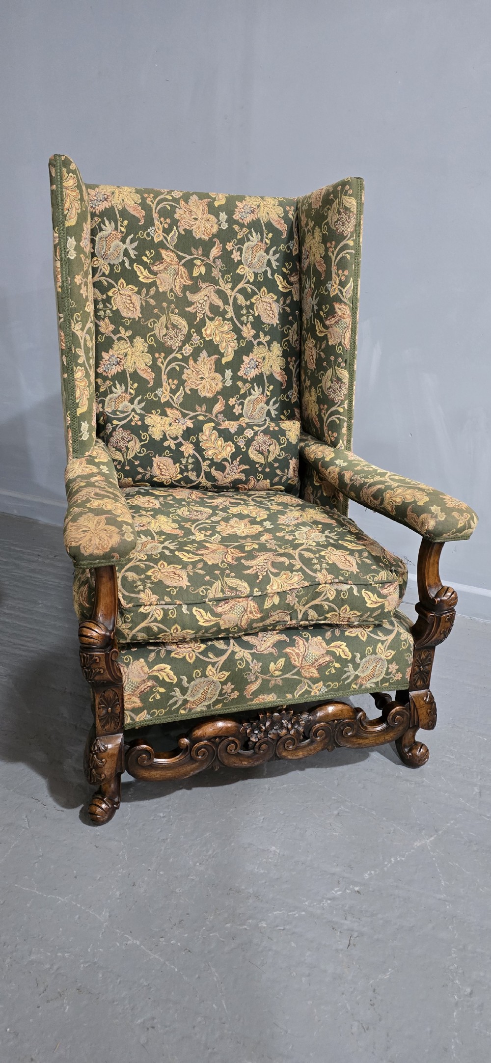A pair of Jacobean revival armchairs with floral green tapestry upholstery and intricately carved walnut bases. View II