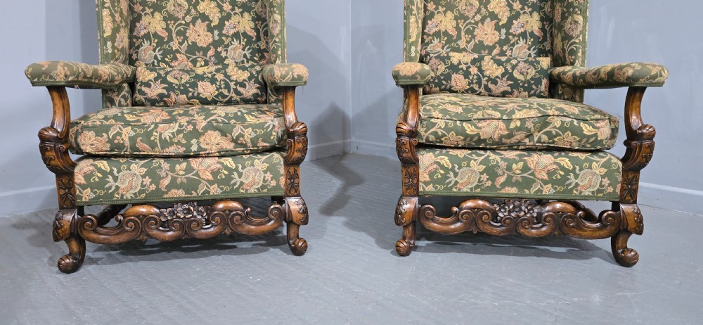 A pair of Jacobean revival armchairs with floral green tapestry upholstery and intricately carved walnut bases. View IV