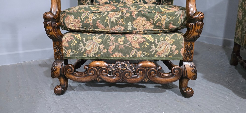 A pair of Jacobean revival armchairs with floral green tapestry upholstery and intricately carved walnut bases. View V
