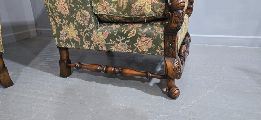 A pair of Jacobean revival armchairs with floral green tapestry upholstery and intricately carved walnut bases. View VIII