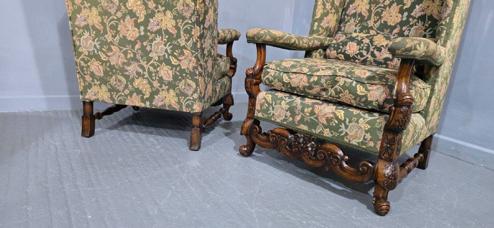 A pair of Jacobean revival armchairs with floral green tapestry upholstery and intricately carved walnut bases. View XII