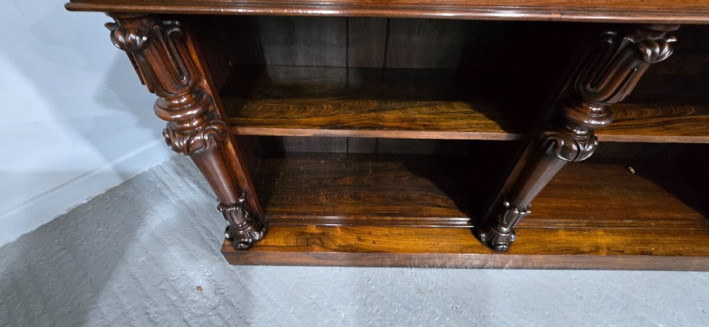 A large 19th-century William IV open mahogany waterfall bookcase with tiered graduated shelves filled with books and carved pilasters. View X