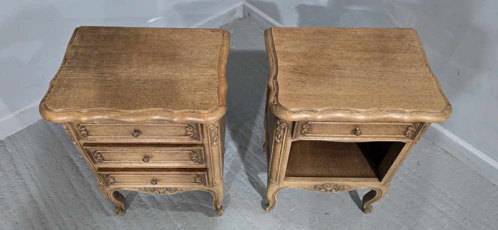 A pair of French bleached oak bedside cabinets featuring cabriole legs, carved aprons, and moulded drawer fronts, with one unit containing three drawers and the other featuring a single drawer above an open shelf. View III
