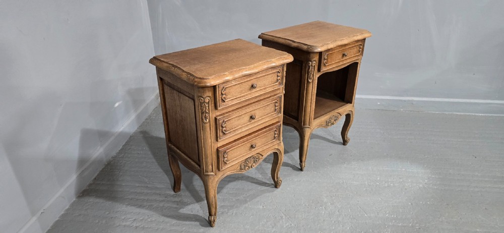 A pair of French bleached oak bedside cabinets featuring cabriole legs, carved aprons, and moulded drawer fronts, with one unit containing three drawers and the other featuring a single drawer above an open shelf. View VI