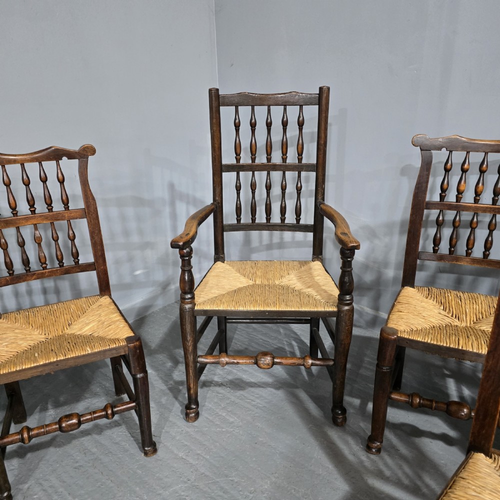 A set of six dark brown 19th-century country dining chairs featuring spindle backrests and woven rush seats. View II