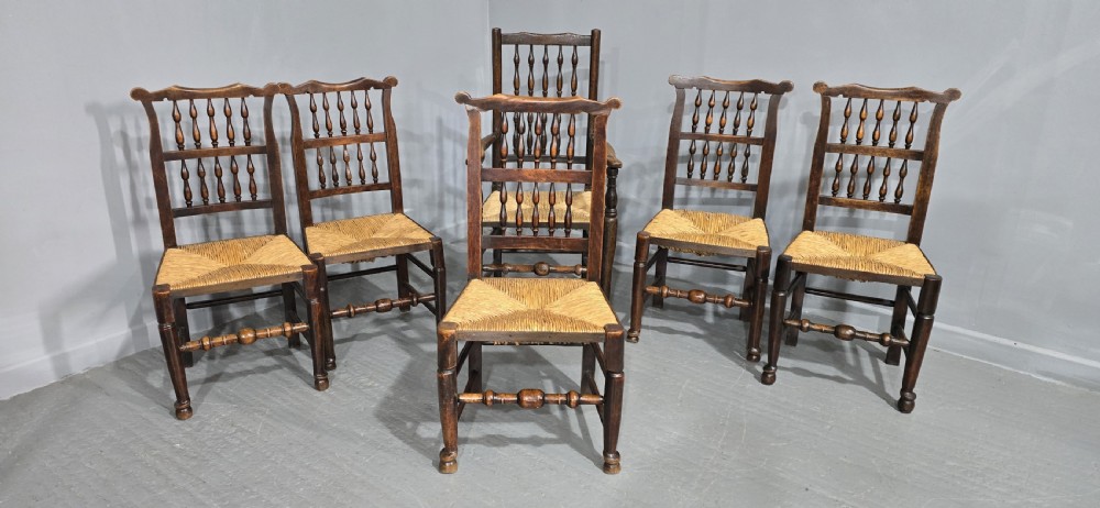 A set of six dark brown 19th-century country dining chairs featuring spindle backrests and woven rush seats. View III