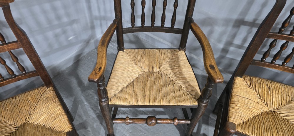 A set of six dark brown 19th-century country dining chairs featuring spindle backrests and woven rush seats. View VII