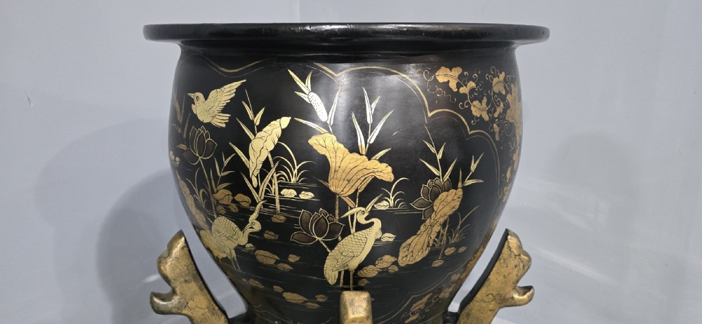 A large black lacquered oriental jardiniere decorated with gold floral and bird imagery, resting upon a carved gold giltwood dragon-form stand. View III