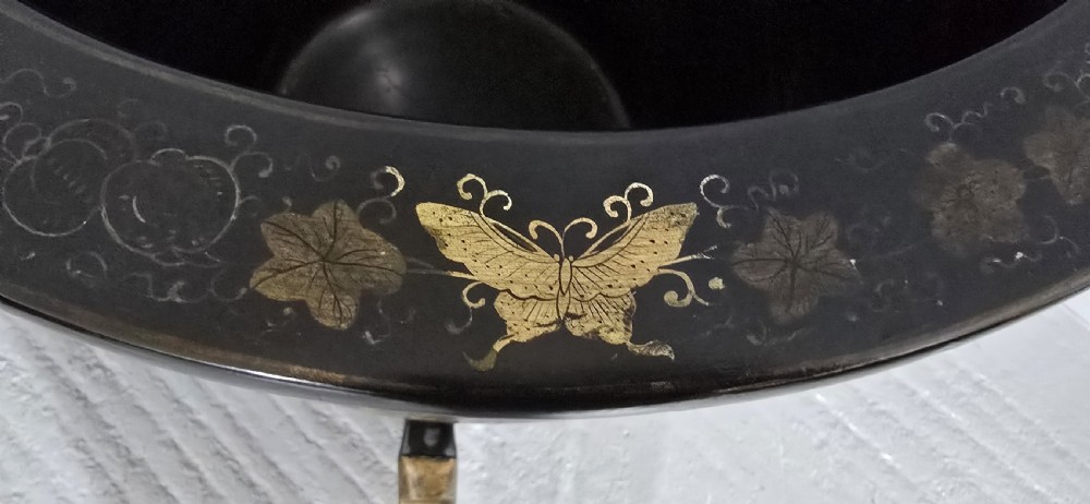 A large black lacquered oriental jardiniere decorated with gold floral and bird imagery, resting upon a carved gold giltwood dragon-form stand. View VIII