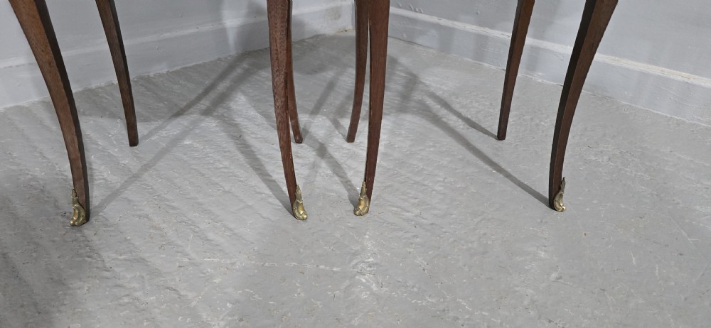 A pair of French Louis XV style bedside tables featuring floral marquetry wood veneers, three drawers, gilt brass mounts, and slender cabriole legs. View V