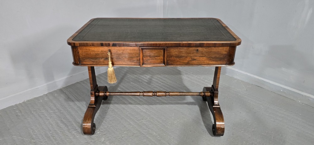A Regency dark rosewood writing sofa table with a leather-inset top, frieze drawers, scroll feet, and a turned stretcher. View II