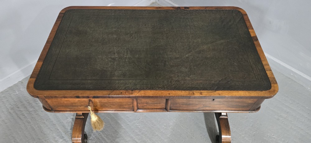 A Regency dark rosewood writing sofa table with a leather-inset top, frieze drawers, scroll feet, and a turned stretcher. View IX
