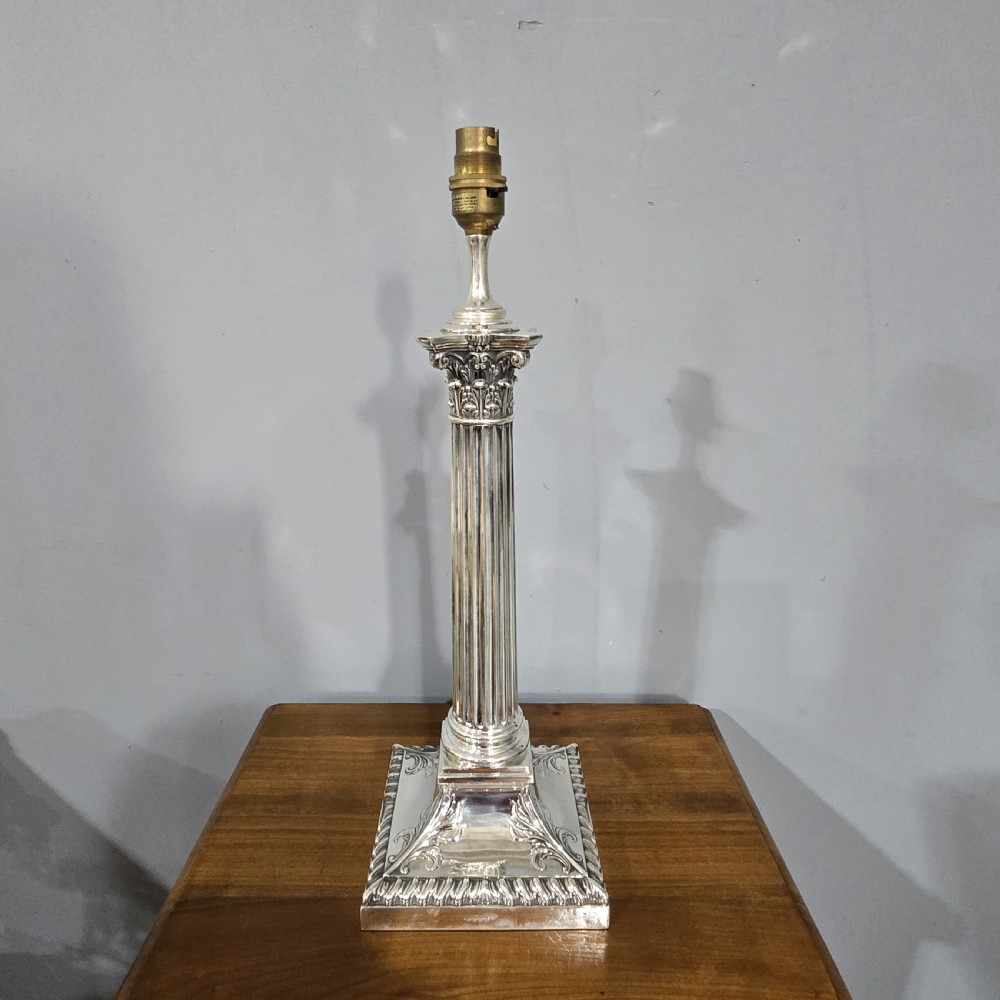 An antique silver-plated table lamp designed as a fluted Corinthian column set upon a decorative square base. View II