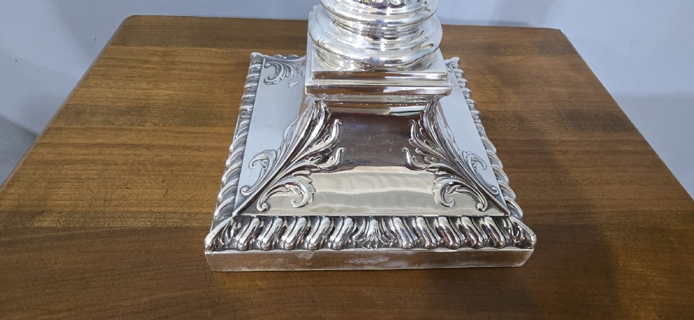 An antique silver-plated table lamp designed as a fluted Corinthian column set upon a decorative square base. View III