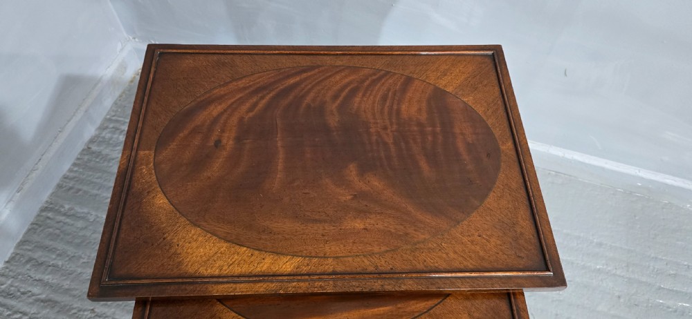 A set of four graduated mahogany quartetto tables featuring oval inlaid tops, ring-turned spindle legs, and curved stretchers. View VII