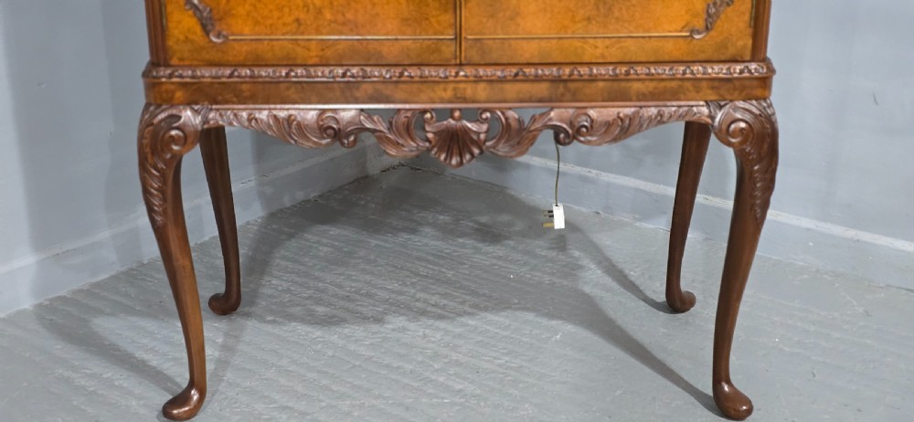 A freestanding burr walnut cocktail cabinet with double doors, carved shell apron, and cabriole legs. View II