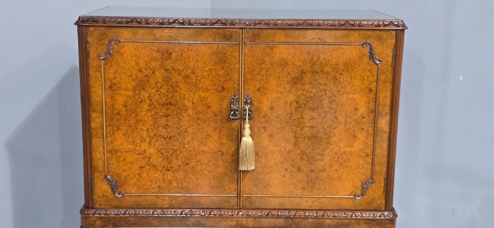 A freestanding burr walnut cocktail cabinet with double doors, carved shell apron, and cabriole legs. View III