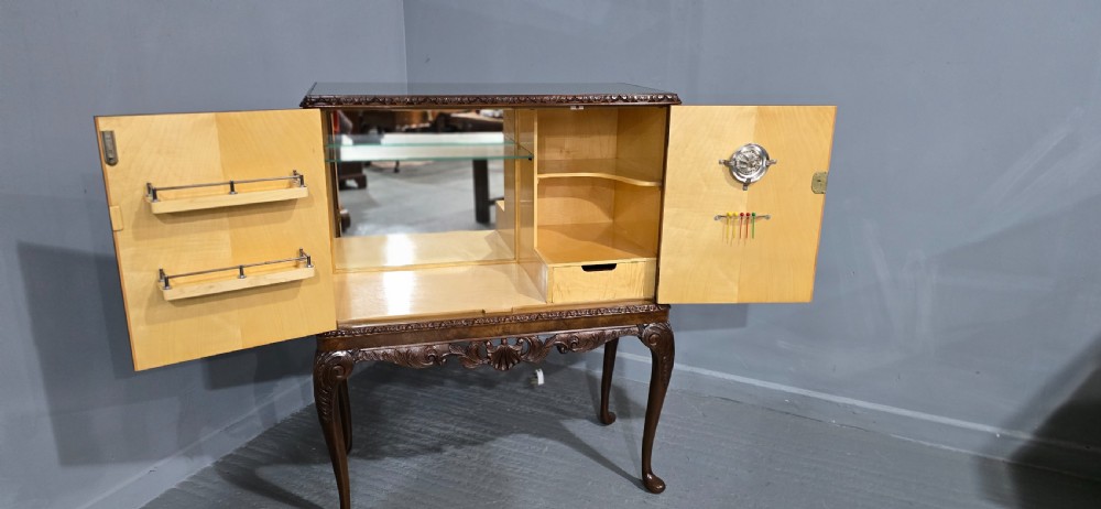 A freestanding burr walnut cocktail cabinet with double doors, carved shell apron, and cabriole legs. View VI