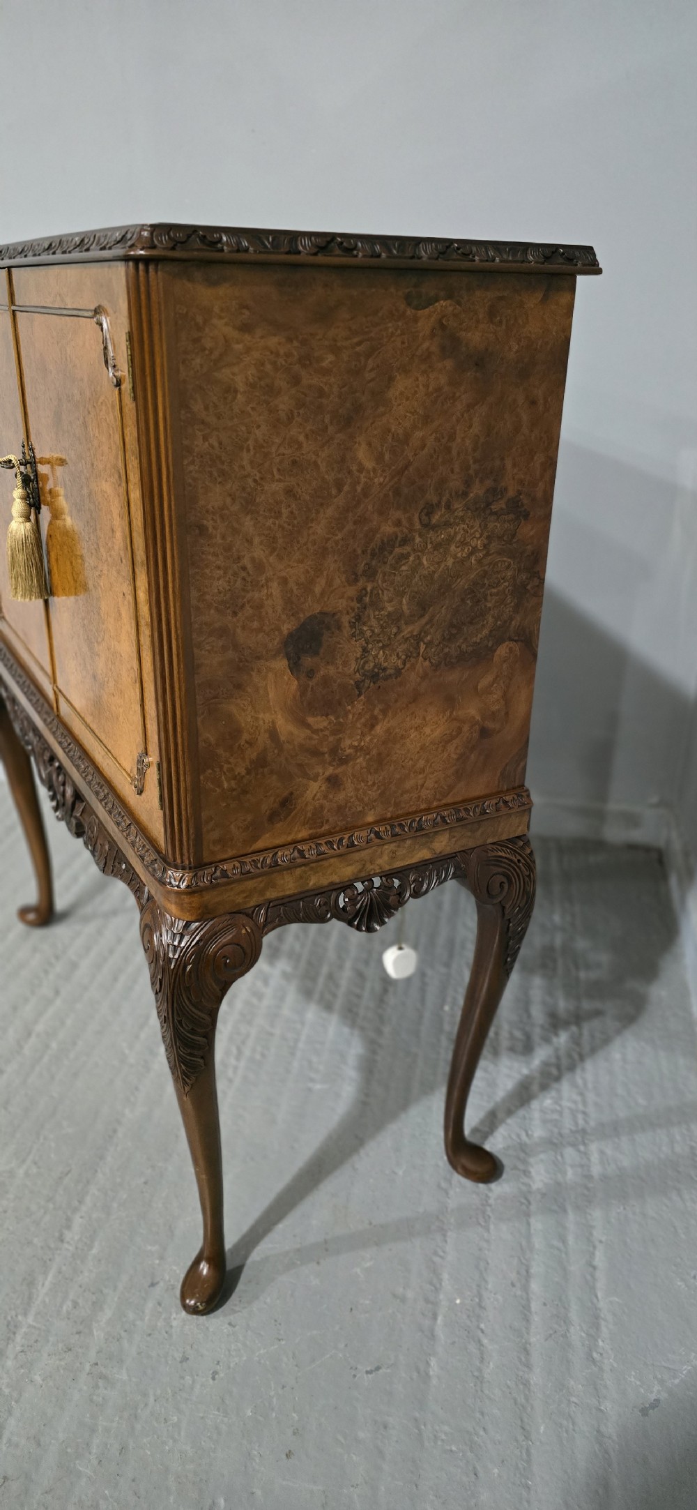A freestanding burr walnut cocktail cabinet with double doors, carved shell apron, and cabriole legs. View X
