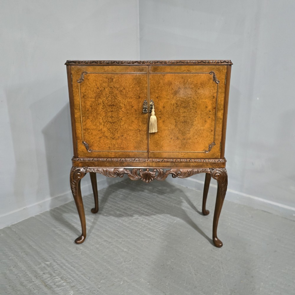 A freestanding burr walnut cocktail cabinet with double doors, carved shell apron, and cabriole legs. View XII