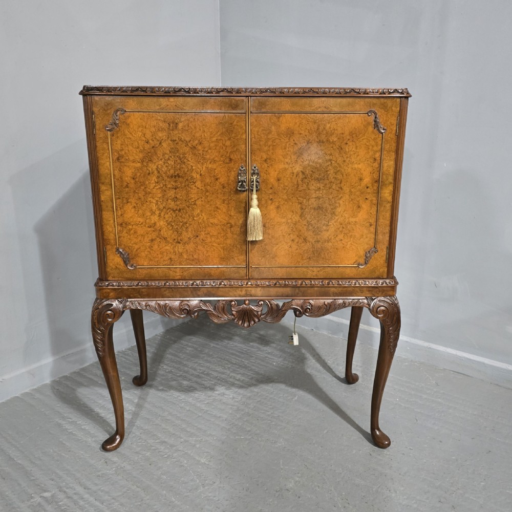A freestanding burr walnut cocktail cabinet with double doors, carved shell apron, and cabriole legs. View XIII