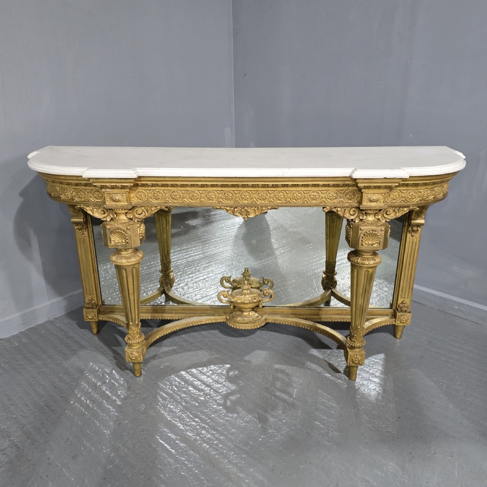 A Victorian giltwood console table featuring a white marble top, mirrored back panel, fluted tapered legs, and a carved rosette frieze. View II
