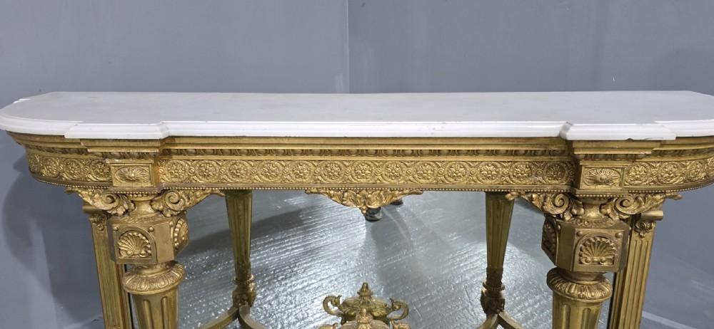 A Victorian giltwood console table featuring a white marble top, mirrored back panel, fluted tapered legs, and a carved rosette frieze. View VIII