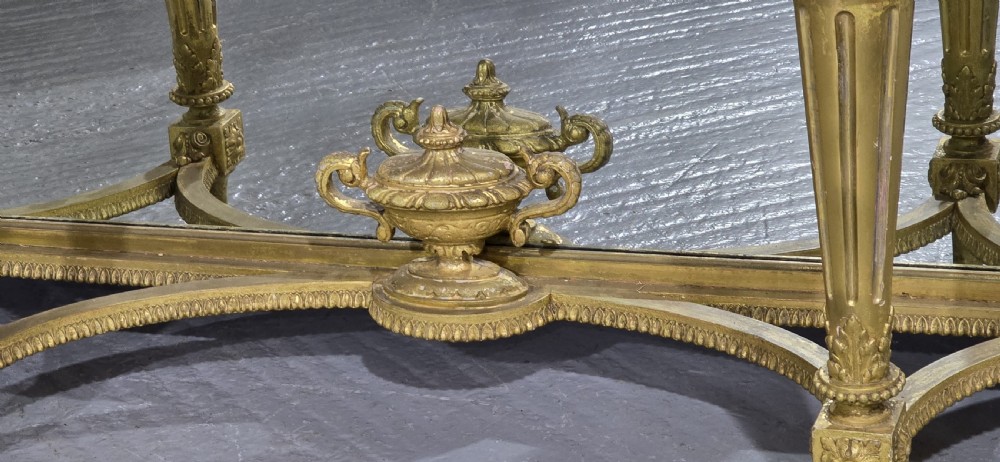 A Victorian giltwood console table featuring a white marble top, mirrored back panel, fluted tapered legs, and a carved rosette frieze. View IX
