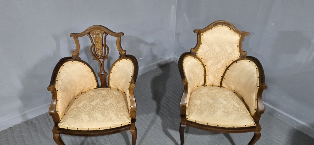 A pair of Edwardian Art Nouveau mahogany armchairs featuring cream floral upholstery, decorative back splats with marquetry inlay, and curved legs. View IV