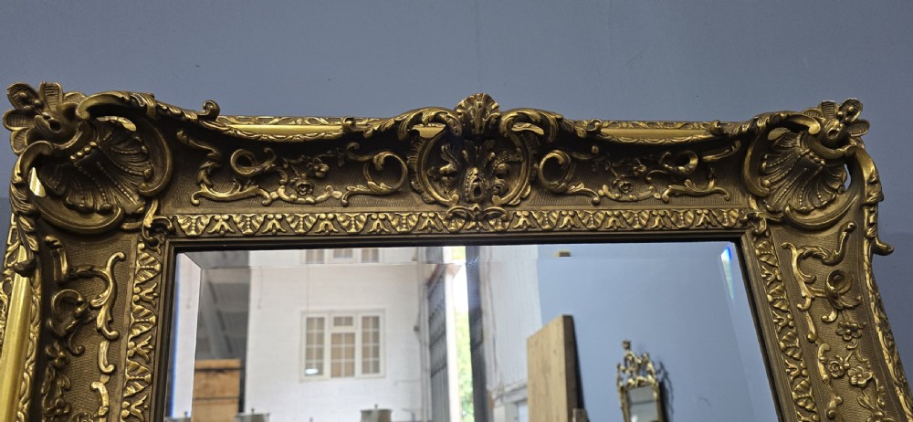 A pair of matching rectangular wall mirrors featuring gold giltwood frames embellished with ornate shell motifs and relief scrollwork. View IV