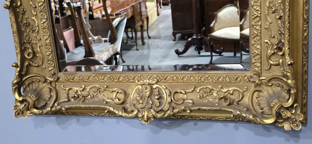A pair of matching rectangular wall mirrors featuring gold giltwood frames embellished with ornate shell motifs and relief scrollwork. View V