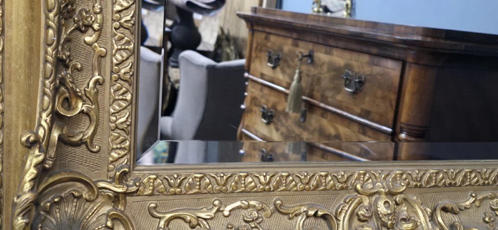 A pair of matching rectangular wall mirrors featuring gold giltwood frames embellished with ornate shell motifs and relief scrollwork. View X