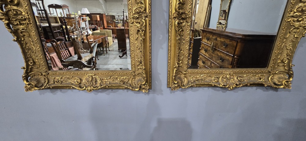 A pair of matching rectangular wall mirrors featuring gold giltwood frames embellished with ornate shell motifs and relief scrollwork. View XI