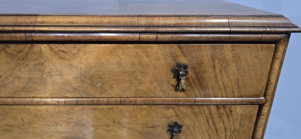A tall antique burr walnut chest of drawers featuring six graduated drawers with brass drop handles and cabriole legs. View VII