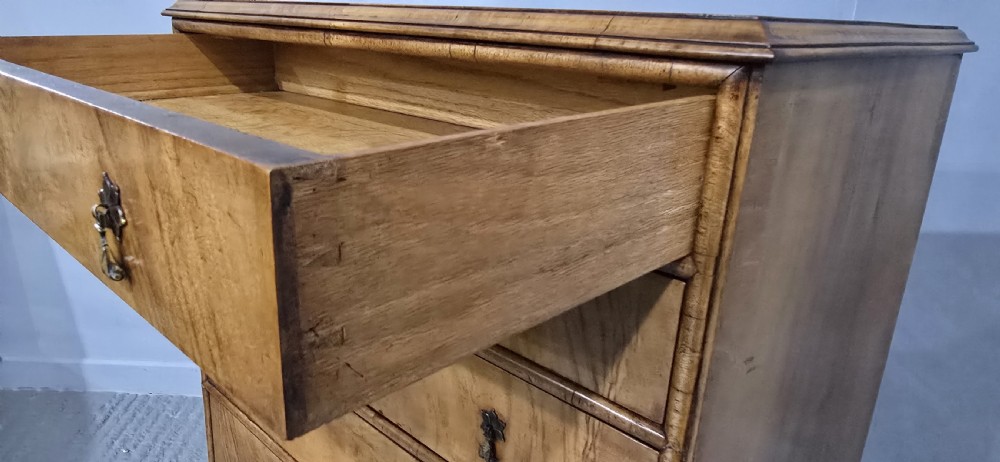 A tall antique burr walnut chest of drawers featuring six graduated drawers with brass drop handles and cabriole legs. View XI