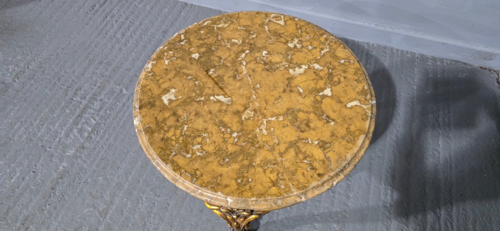 A circular French style low coffee table with a polished beige marble top and carved giltwood cabriole legs. View VI