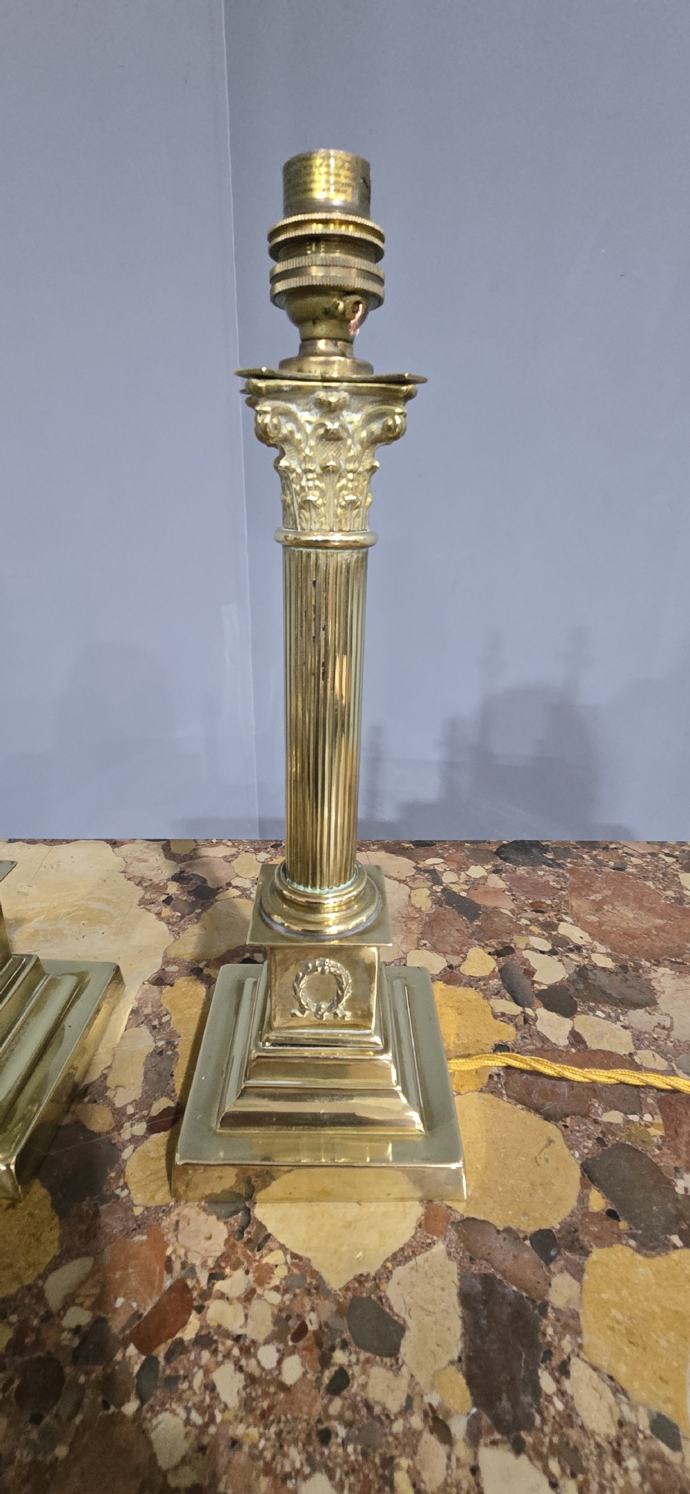 A pair of antique cast brass table lamps styled as classical fluted Corinthian columns with stepped bases. View II